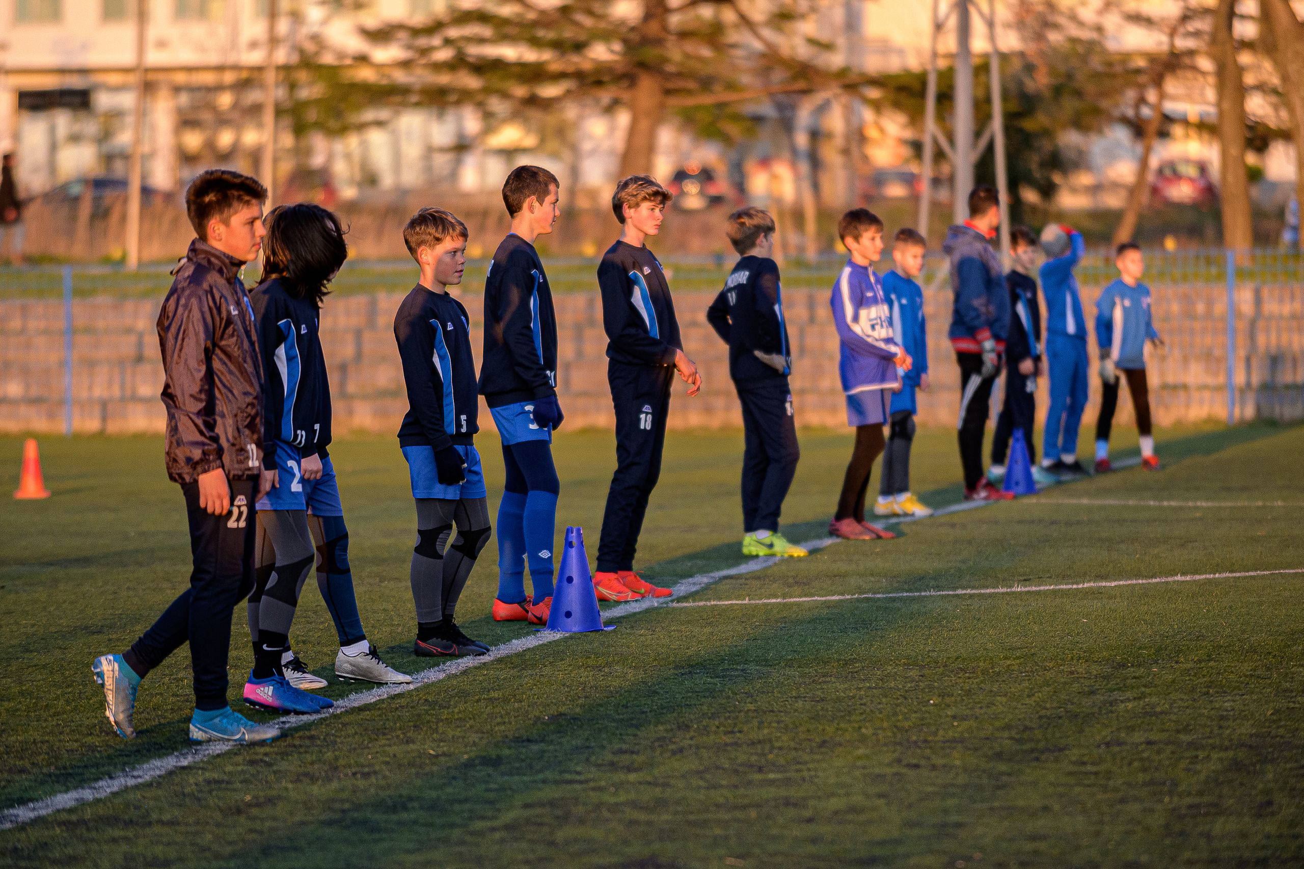 Young soccer team standing in a line during practice session outdoors.